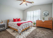 Thumbnail 40 of 48 - A bedroom with a bed, dresser, and ceiling fan.