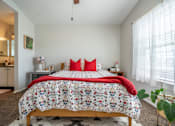 Thumbnail 39 of 48 - A bedroom with a large bed and a red pillow.