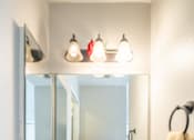 Thumbnail 46 of 48 - A bathroom with a sink, mirror, and lights.