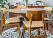 Thumbnail 34 of 48 - A dining room with a table, chairs, and a vase of flowers.