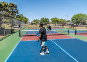 Thumbnail 14 of 31 - people playing tennis on a tennis court  at The Village at Cottonwood Springs, Texas
