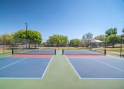 Thumbnail 15 of 31 - a tennis court with four tennis courts on it on a sunny day  at The Village at Cottonwood Springs, El Paso, TX, 79934
