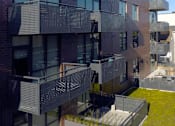 Thumbnail 26 of 31 - A modern building with a balcony and glass windows.