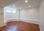 Thumbnail 3 of 13 - A room with wooden floors and white walls.
