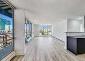 Thumbnail 5 of 54 - A spacious room with wooden flooring and a large window overlooking a cityscape.