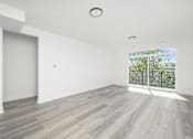 Thumbnail 10 of 27 - A spacious room with a large window and a sliding glass door.