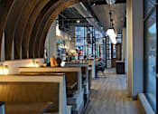 Thumbnail 25 of 31 - A modern restaurant with wooden tables and chairs.