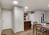 Thumbnail 11 of 15 - a living room and kitchen with a table and chairs