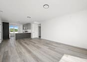 Thumbnail 12 of 27 - A spacious room with a grey floor and white walls.