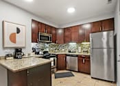 Thumbnail 3 of 15 - a kitchen with stainless steel appliances and granite counter tops