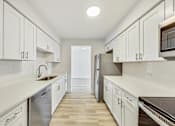 Thumbnail 20 of 54 - A kitchen with white cabinets and a stainless steel refrigerator.