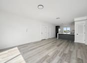 Thumbnail 13 of 27 - A spacious room with a grey floor and white walls.