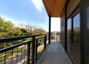 Thumbnail 11 of 61 - A balcony with a black railing and a wooden floor.