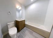 Thumbnail 12 of 61 - A white toilet sits next to a bathtub in a bathroom.