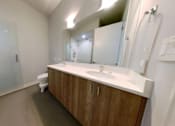 Thumbnail 8 of 61 - A bathroom with a toilet, sink, and mirror.