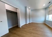 Thumbnail 17 of 61 - A room with wooden flooring and a window with blinds.