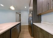 Thumbnail 5 of 61 - A kitchen with dark wood cabinets and a marble countertop.