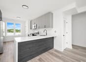 Thumbnail 14 of 27 - A modern kitchen with a refrigerator, microwave, and oven.