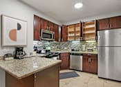 Thumbnail 4 of 15 - a kitchen with stainless steel appliances and granite counter tops