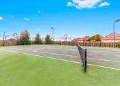 Thumbnail 20 of 23 - A tennis court with a net and a sign on it.