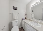 Thumbnail 20 of 37 - A white toilet with a white towel on top of it.