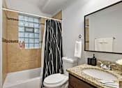 Thumbnail 8 of 15 - a bathroom with a shower toilet and sink and a mirror