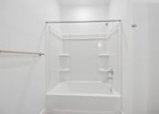 Thumbnail 52 of 60 - A white bathroom with a tub and shower.