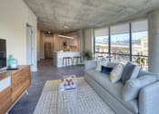 Thumbnail 3 of 31 - A modern living room with a grey sofa and a wooden cabinet.
