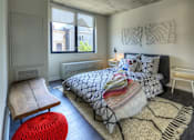 Thumbnail 2 of 31 - A bedroom with a bed, a chair, and a window.