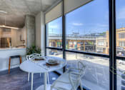 Thumbnail 8 of 31 - A white table with chairs is set up in a room with a view of the street outside.
