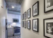 Thumbnail 19 of 31 - A hallway with a series of framed pictures on the wall.