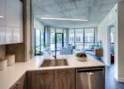 Thumbnail 9 of 31 - A modern kitchen with a stainless steel dishwasher and wooden cabinets.