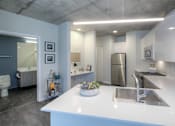 Thumbnail 16 of 31 - A modern kitchen with a white countertop and stainless steel appliances.