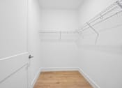 Thumbnail 53 of 60 - A white closet with a door and shelves.