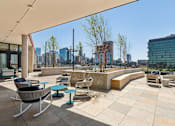 Thumbnail 78 of 84 - A patio with chairs and a table with a view of the city.