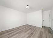 Thumbnail 19 of 27 - A room with a wooden floor and a smoke detector on the ceiling.