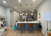 Thumbnail 20 of 45 - A modern kitchen with a bar area and two stools.