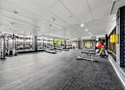 Thumbnail 7 of 54 - A gym with a variety of equipment including treadmills, weights, and exercise machines.