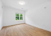 Thumbnail 54 of 60 - A room with a window and wooden flooring.