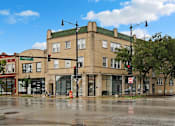 Thumbnail 1 of 15 - a large building on the corner of a street with traffic lights
