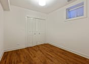 Thumbnail 9 of 13 - A room with a white door and wooden flooring.