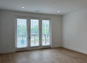 Thumbnail 15 of 24 - A room with a sliding glass door and wooden flooring.