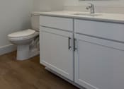 Thumbnail 22 of 24 - A white toilet sits next to a sink in a bathroom.