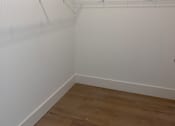 Thumbnail 18 of 24 - Empty room with a white wall and a wooden floor.