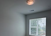 Thumbnail 17 of 24 - A room with a window and wooden flooring.