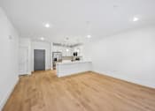 Thumbnail 37 of 60 - A large empty room with wooden floors and white walls.