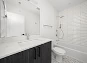 Thumbnail 20 of 27 - A white bathroom with a sink, toilet, and bathtub.