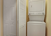 Thumbnail 31 of 31 - A white washing machine in a small room.