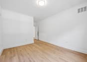 Thumbnail 55 of 60 - A room with wooden flooring and a white door.