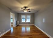 Thumbnail 12 of 15 - an empty living room with a ceiling fan and a window